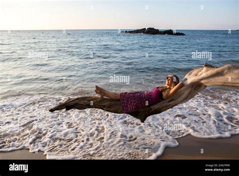 mujer tumbada en la playa|mujer tumbada en la arena de la playa con las sombras del sol .